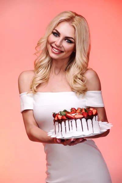 Schöne junge Frau hält selbstgebackenen Kuchen isoliert — Stockfoto