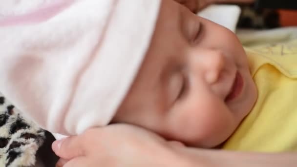 Un piccolo bambino carino sta guardando nella fotocamera e indossa un cappello rosa . — Video Stock