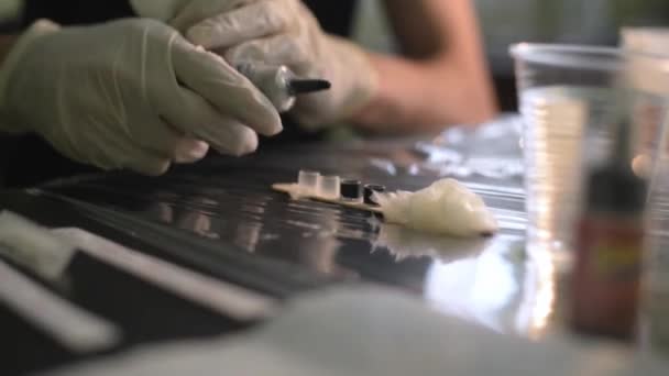 En tattooist häller bläck i små behållare — Stockvideo