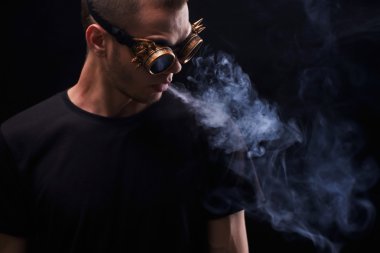 Çılgın güneş gözlüklü adam portresi. Bir adam sigara cigare. Siyah arka plan üzerine izole.