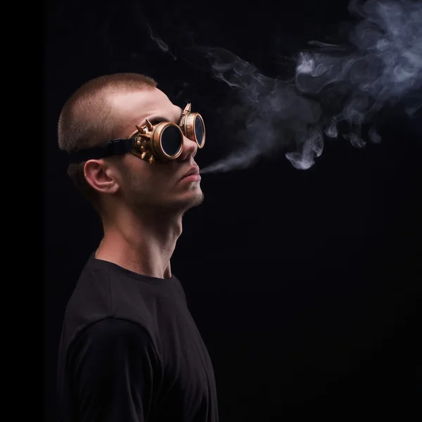 Portret van man in gekke zonnebril. Een man roken sigaren. Geïsoleerd op zwarte achtergrond. — Stockfoto