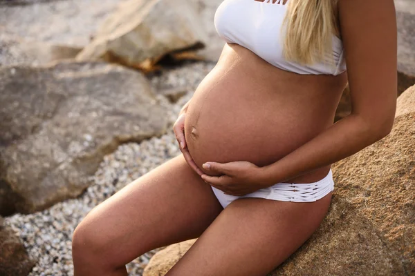 Foto primo piano di pancia di una ragazza incinta sopra la piscina arguzia — Foto Stock