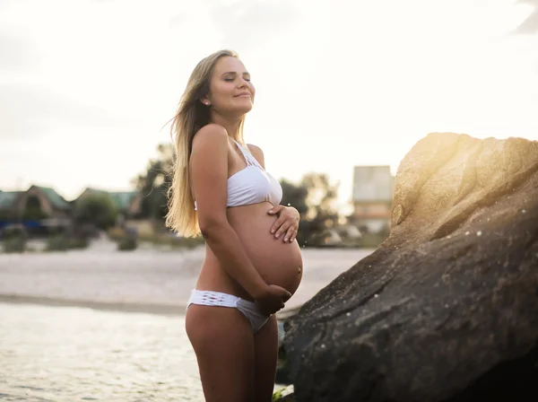 Schöne schwangere Frau am blauen Strand im Sommer — Stockfoto