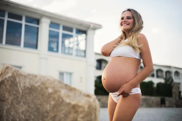 Schöne schwangere Frau am blauen Strand im Sommer — Stockfoto