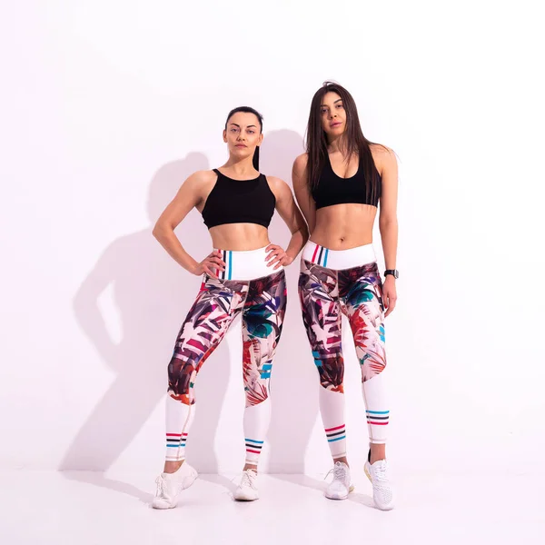 Gesund Durchtrainierte Frauen Tragen Die Gleiche Sportbekleidung Auf Weißem Hintergrund — Stockfoto