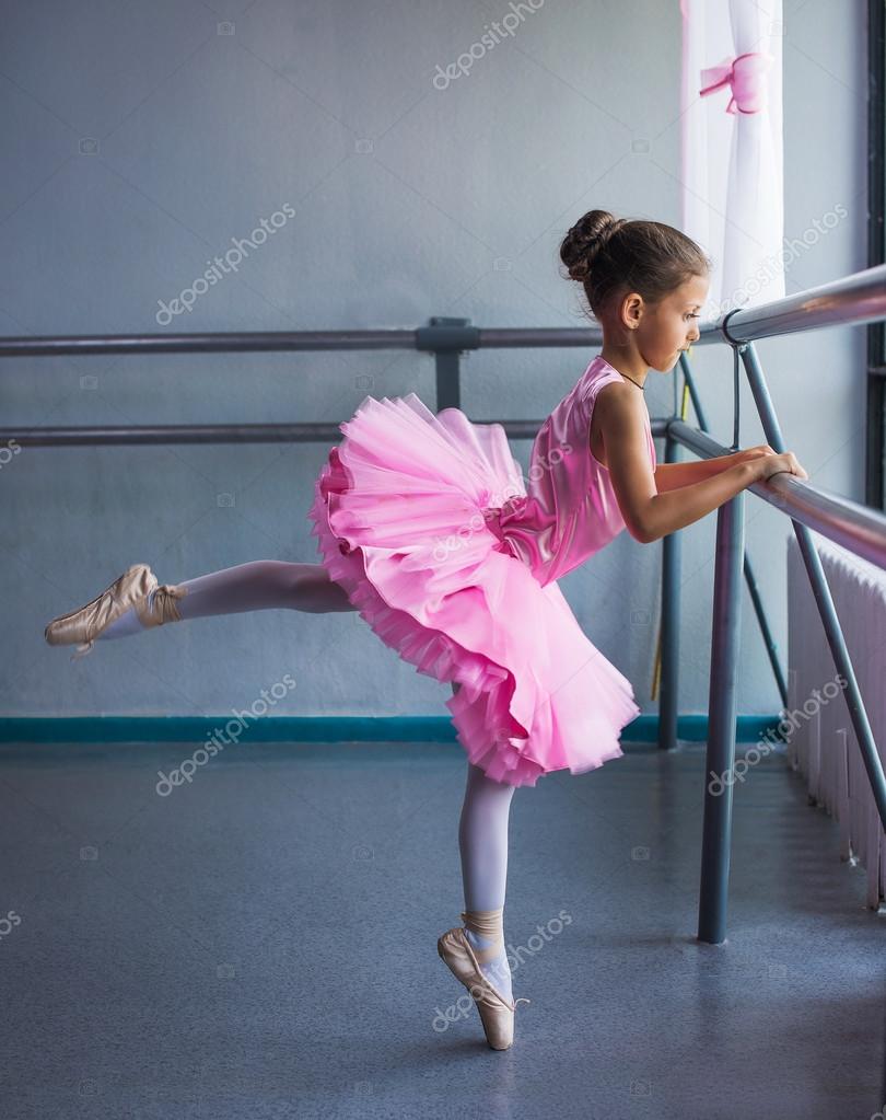 Young ballerina in a pink ballet tutu is dancing in dance class Stock Photo  by ©VlaDee 82601556