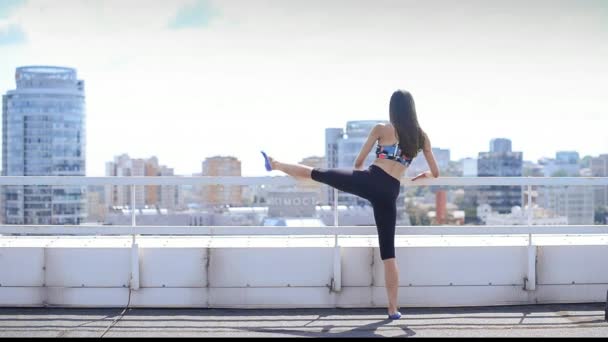 Beautiful sports girl does exercises Pilates and yoga on the roof — Stock Video