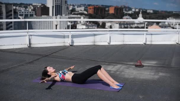 Mulher fazendo exercícios de ioga e pilates no telhado do arranha-céu da cidade — Vídeo de Stock