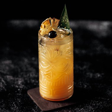 Barda servis edilen buzlu ananas kokteylini tazeliyorum. Süslü bar veya restoran ortamında tropik yaz içeceği konsepti.