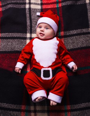 Mavi arka planda Noel Baba şapkası olan küçük tatlı bir kız.