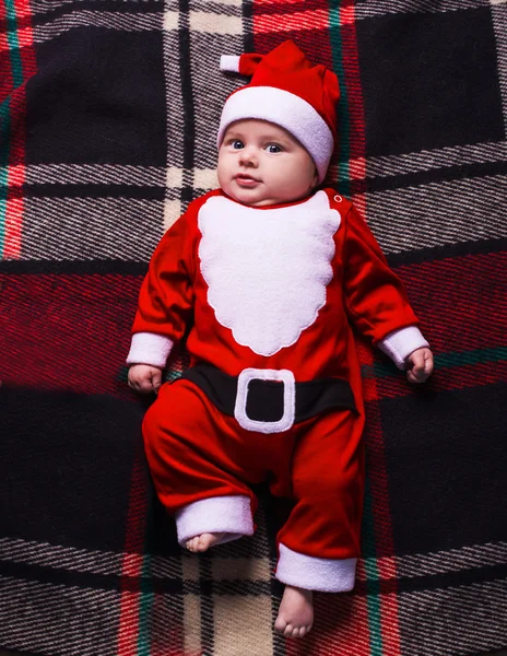 Pequena menina bonito com chapéu de santa no fundo azul — Fotografia de Stock