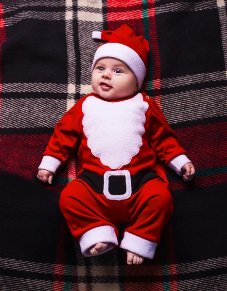 Pequena menina bonito com chapéu de santa no fundo azul — Fotografia de Stock