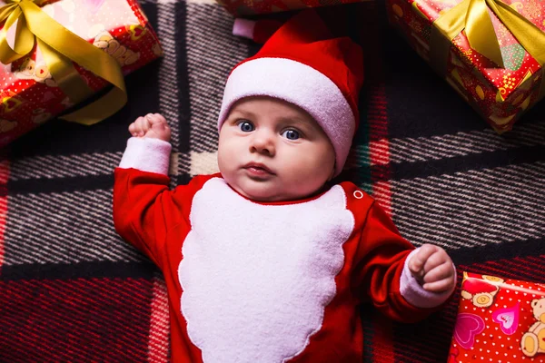 Pequena menina bonito com chapéu de santa no fundo azul — Fotografia de Stock