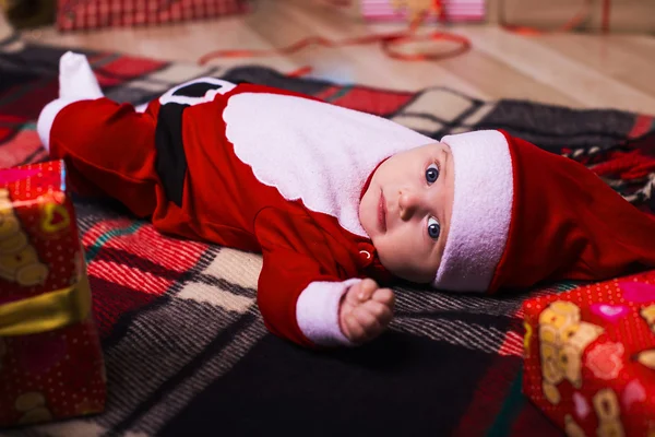 Pequena menina bonito com chapéu de santa no fundo azul — Fotografia de Stock