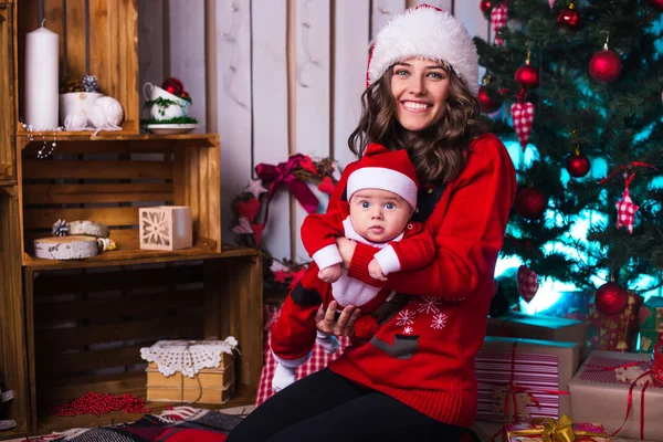 Retrato de mãe feliz e bebê adorável em terno de ajudante do Papai Noel — Fotografia de Stock