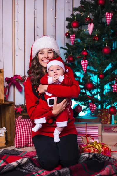 Retrato de mãe feliz e bebê adorável em terno de ajudante do Papai Noel — Fotografia de Stock