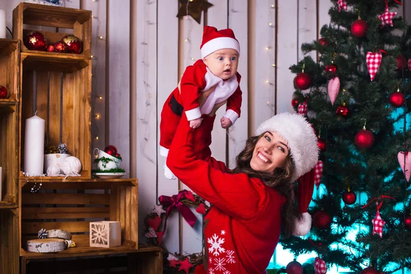 Retrato de mãe feliz e bebê adorável em terno de ajudante do Papai Noel — Fotografia de Stock