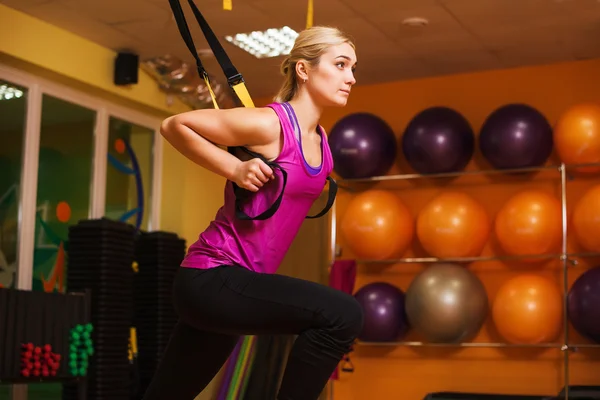 Wanita yang melakukan push up pelatihan lengan dengan tali kebugaran trx di gym Konsep latihan olahraga gaya hidup sehat — Stok Foto