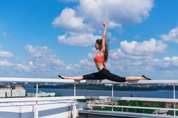 Yoga y meditación en una ciudad urbanística moderna. Chica atractiva joven - yoga medita contra rascacielos modernos — Foto de Stock