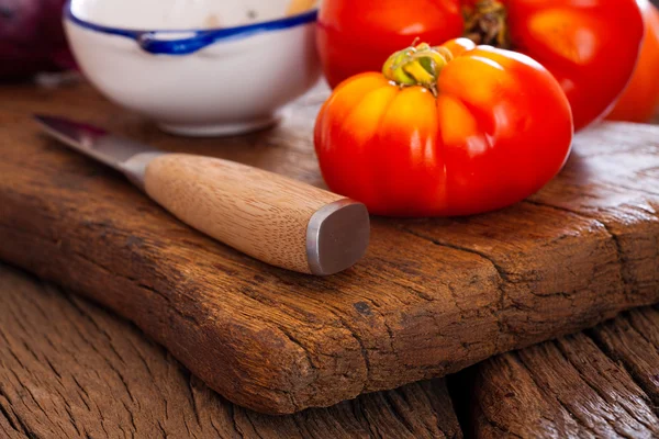 Closeup of a beef tomato and kitchen knife — Stock Photo, Image