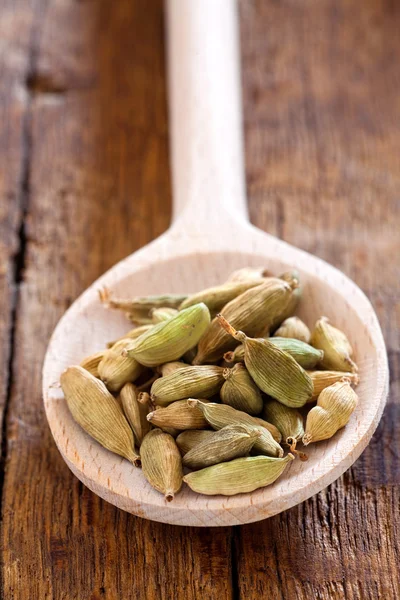 Holzlöffel mit grünen Kardamomschoten — Stockfoto