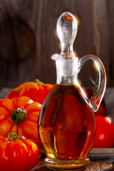 Fresh meat tomatoes and a carafe of olive oil — Stock Photo, Image