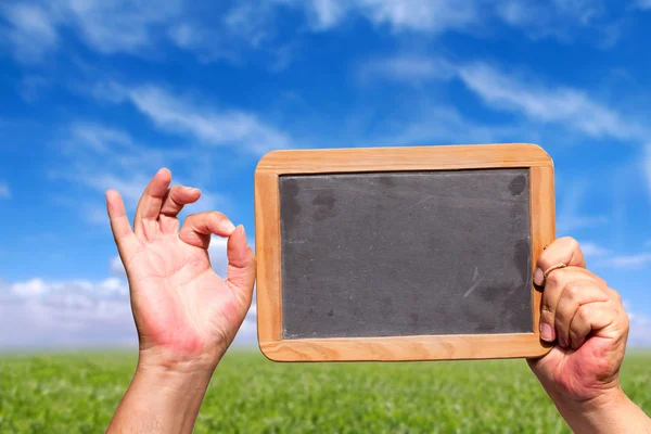 Menschliche Hand zeigt ok Zeichen und halten eine Schiefertafel — Stockfoto