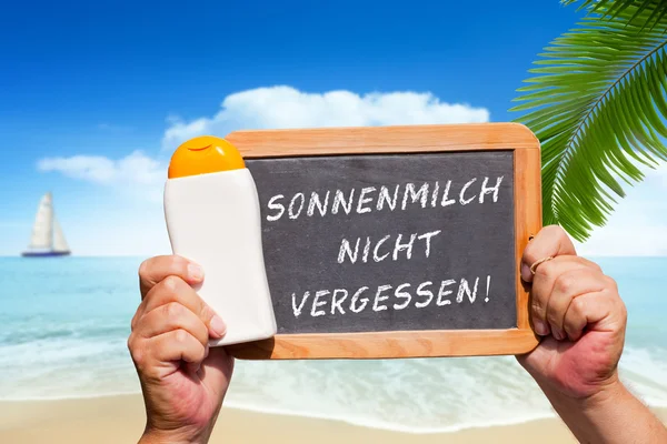 Текстовое сообщение - Sonnenmilch nicht vergessen on a slate — стоковое фото