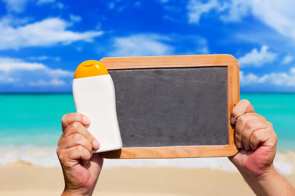 Flasche Sonnenschutz und leere Schiefertafel — Stockfoto