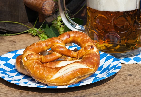 Birra e pretzel su un piatto di carta — Foto Stock