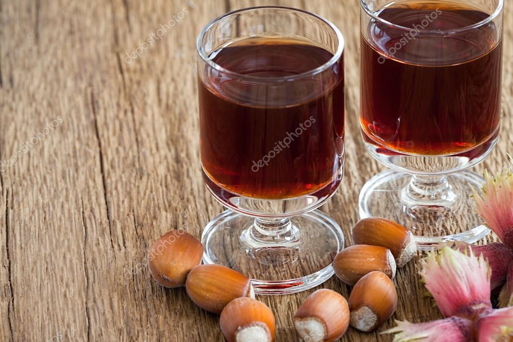 Hazelnut liqueur in two glasses and hazelnuts Stock Photo by