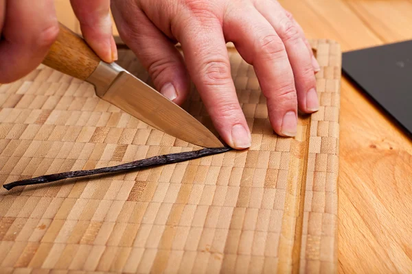 Cutting open the vanilla pod with a knife — Stock Photo, Image