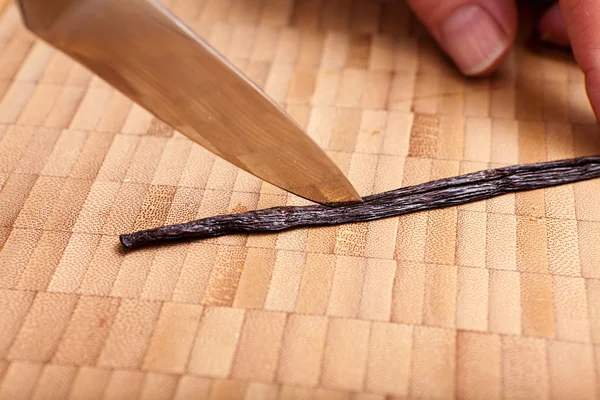 Cutting open the vanilla pod with a knife — Stock Photo, Image