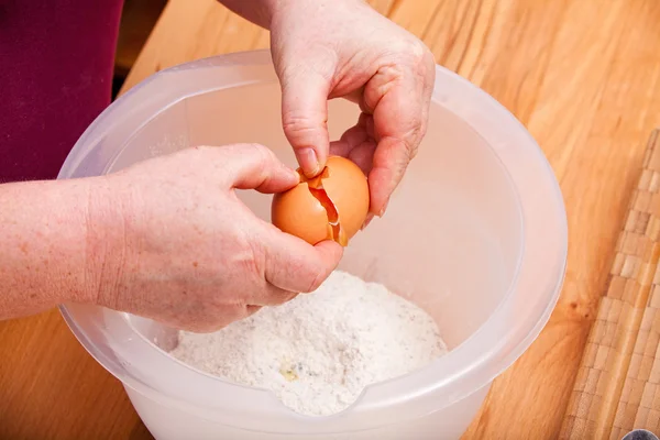 Romper un huevo en la masa de la torta — Foto de Stock