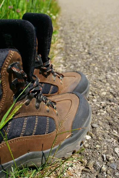 Close-up de botas de caminhada na beira da estrada — Fotografia de Stock
