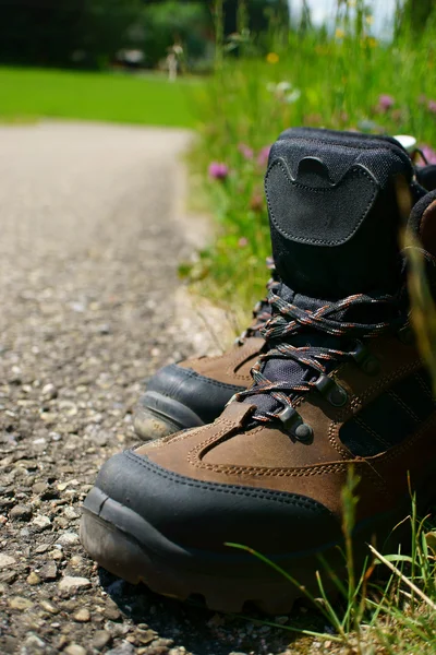 Close-up de botas de caminhada na beira da estrada — Fotografia de Stock