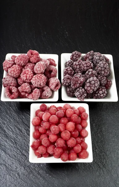 Bowls with three kinds of frozen berries — Stock Photo, Image