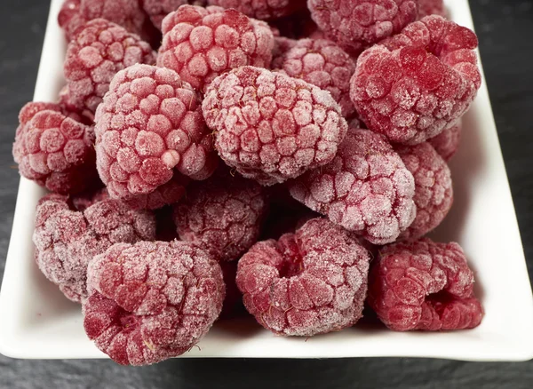 Gefrorene Himbeeren in einer Porzellanschale — Stockfoto