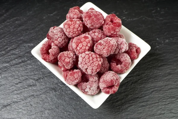 Frozen raspberries in a porcelain dish — Stockfoto