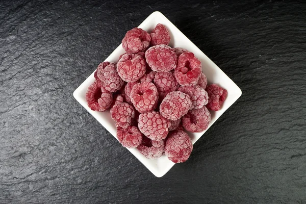 Frozen raspberries in a porcelain dish — Stock Photo, Image