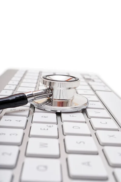 Stethoscope head on computer keyboard — Stock Photo, Image