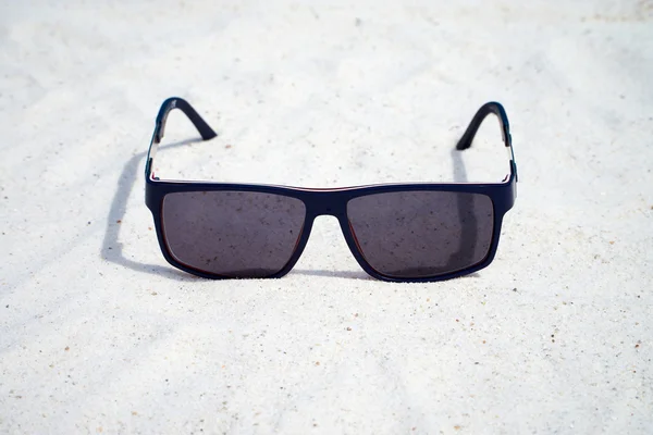 Lunettes de soleil sombres dans le sable — Photo