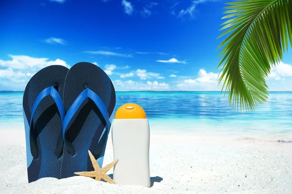 Blue flip flops and suntan lotion — Stock Photo, Image