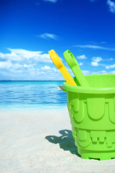 Green plastic bucket on the beach — Stock Photo, Image