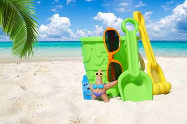 在棕榈叶下多彩沙滩玩具 — 图库照片
