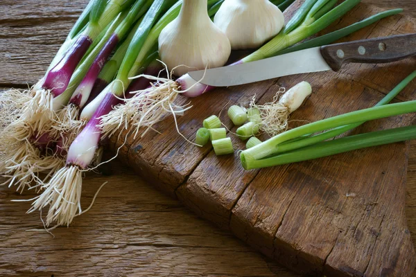 Lente-uitjes, knoflook en keuken mes — Stockfoto