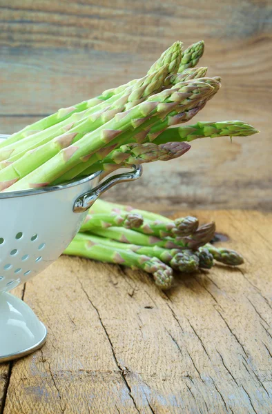 Fresh asparagus in white colander — Stock Photo, Image