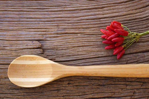 Bunch of red chili pepper and wooden spoon — Stock Photo, Image