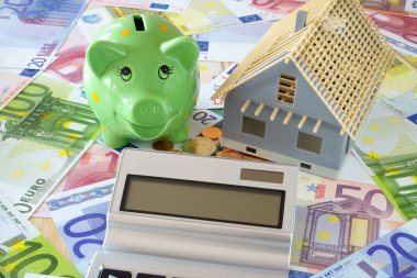 Piggy Bank and Pocket calculator on banknotes