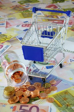 Blue shopping cart and coin stack